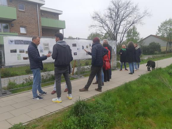 Menschen stehen vor einer Fotoausstellung im öffentlichen Raum