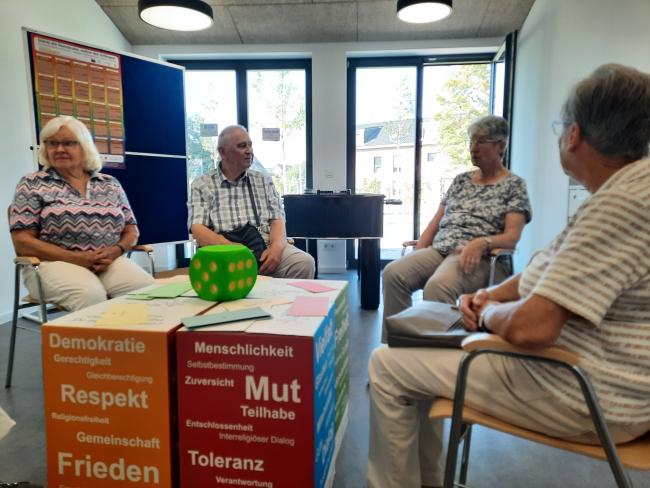 Besucher*innen des Senioren-Frühstücks machen es sich in der Demokratie-Lounge gemütlich