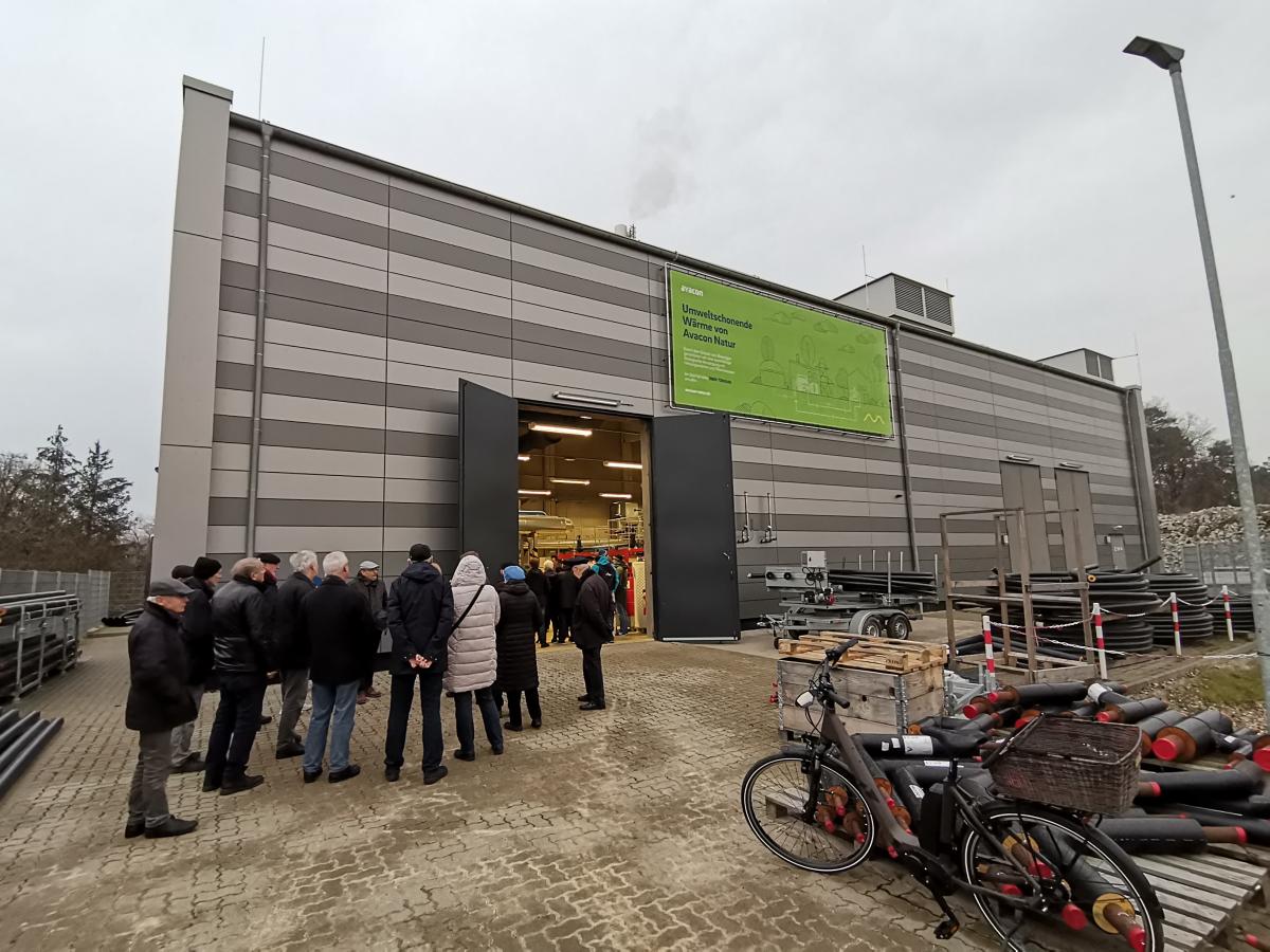 Menschen stehen vor dem Fernwärmekraftwerk im Hanseviertel Lüneburg