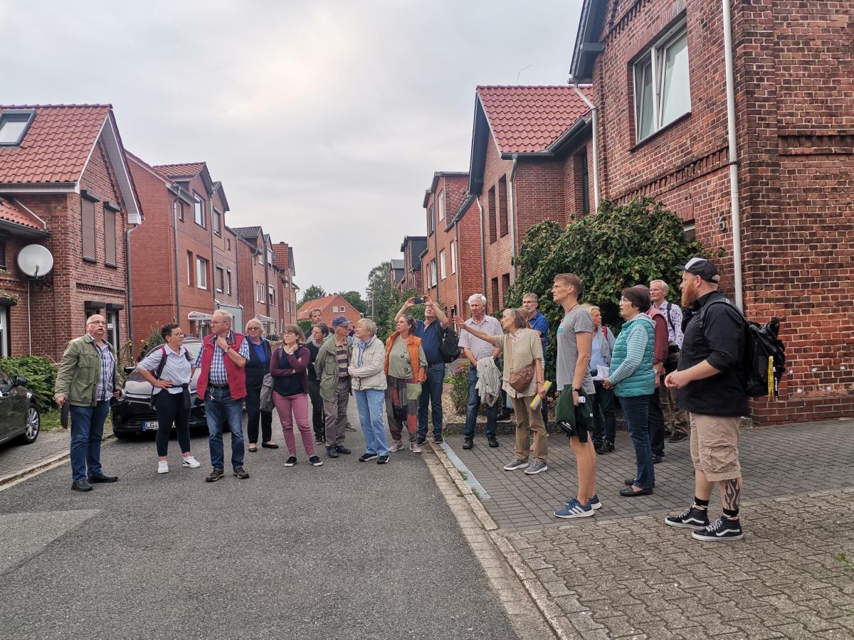 Menschengruppe steht vor einer Häuserreihe